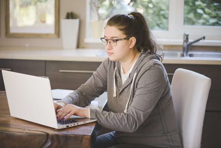 A woman researching the advantages and disadvantages for flat income taxes.