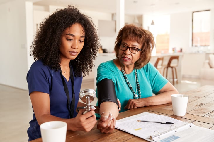 Home health aide taking a patient's blood pressure