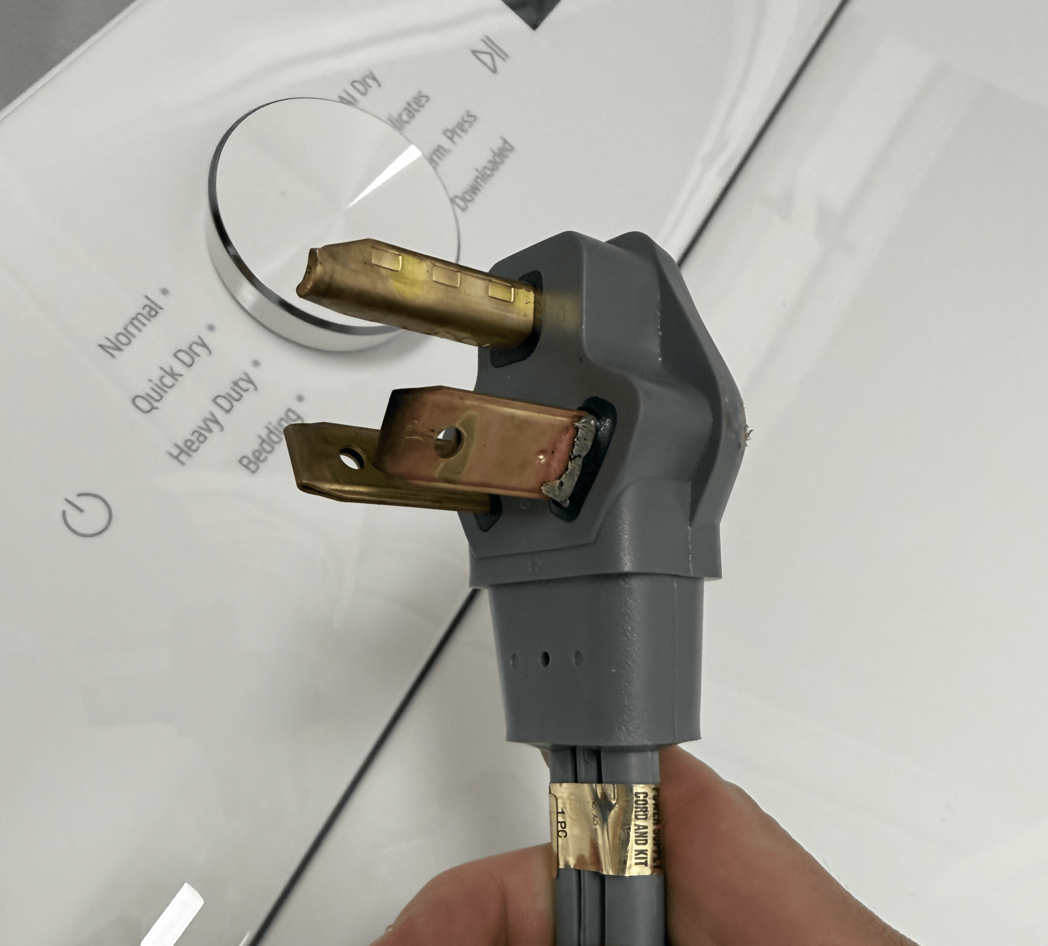 Burnt prong of a three-prong dryer cord after the second time running the dryer
