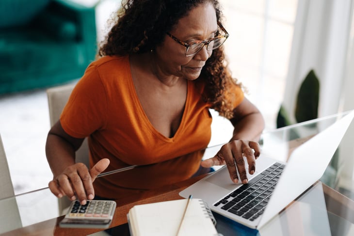 Woman calculating her personal finances, learning to budget and save wisely to ensure a secure and comfortable retirement.